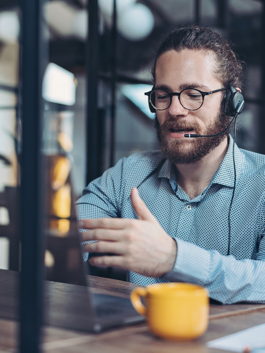 Support-Mitarbeiter von ERAB mit Headset vor einem Laptop